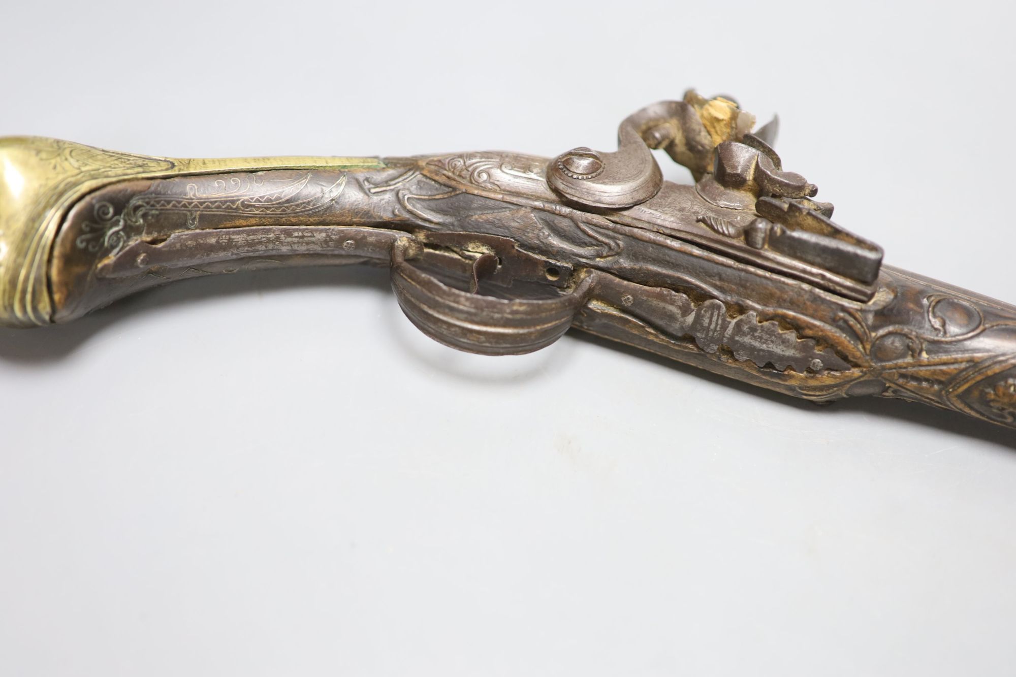 A 19th century Ottoman carved wood and brass mounted flintlock pistol, length 45cm